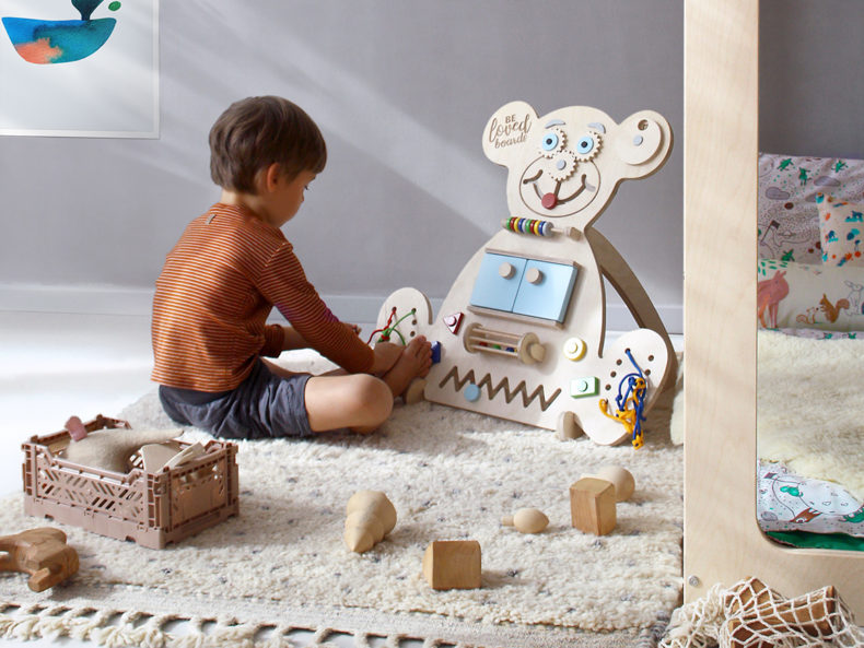 Kind spielt am Busy Board BEAR