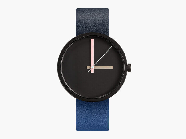 Frontalansicht der Multi Midnight Uhr mit schlichtem Zifferblatt, pinkfarbenem Minutenzeiger und blauem Lederarmband.