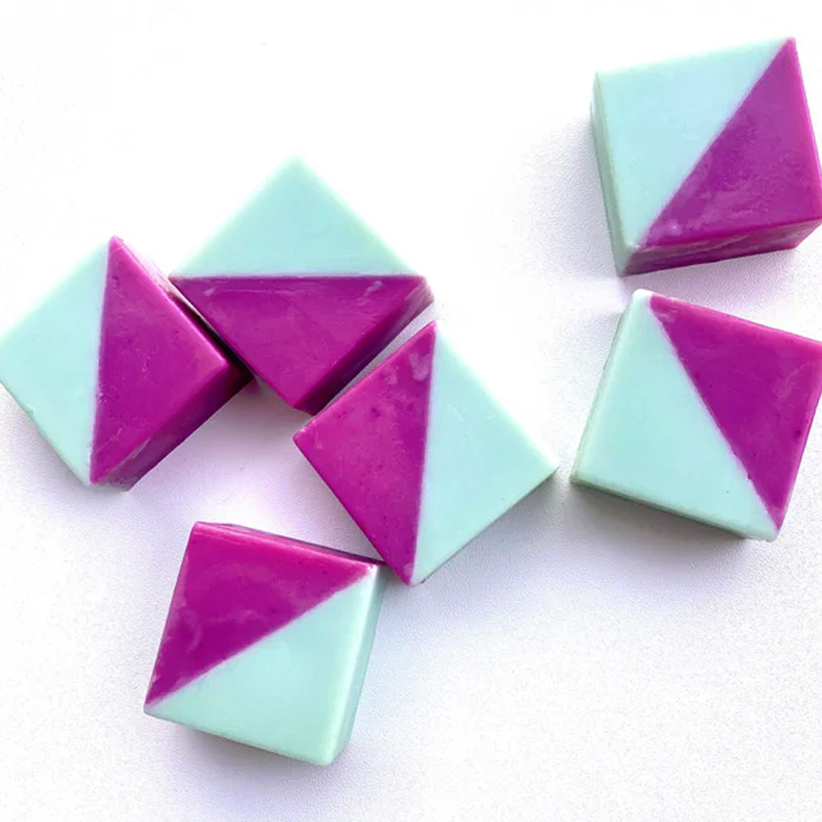 Geometrische zweifarbige Seife „RONJA – Limone & Rosmarin“ in kräftigem Türkis und Lila, dekorativ arrangiert, handgemacht und vegan; kleine 40-g-Seife für normale Haut mit frischem Zitronen-Rosmarin-Duft.