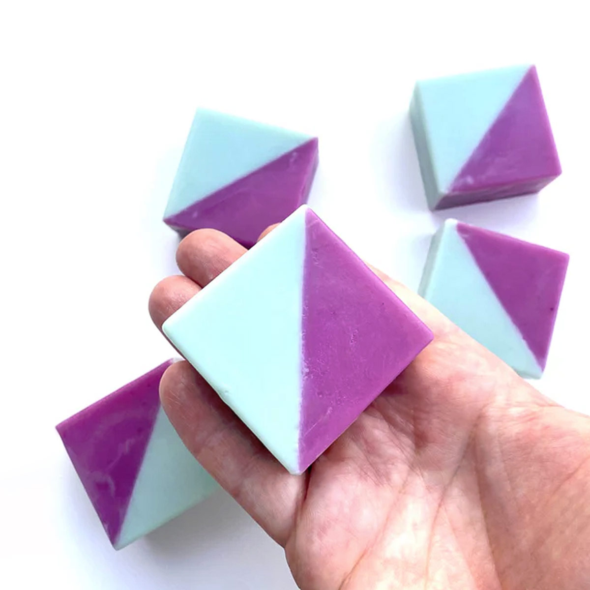 Zweifarbige geometrische Seife „RONJA – Limone & Rosmarin“ in Türkis und Lila, handgemacht und vegan; kleine rechteckige 40-g-Seife mit frischem Zitrus-Rosmarin-Duft auf heller Oberfläche.