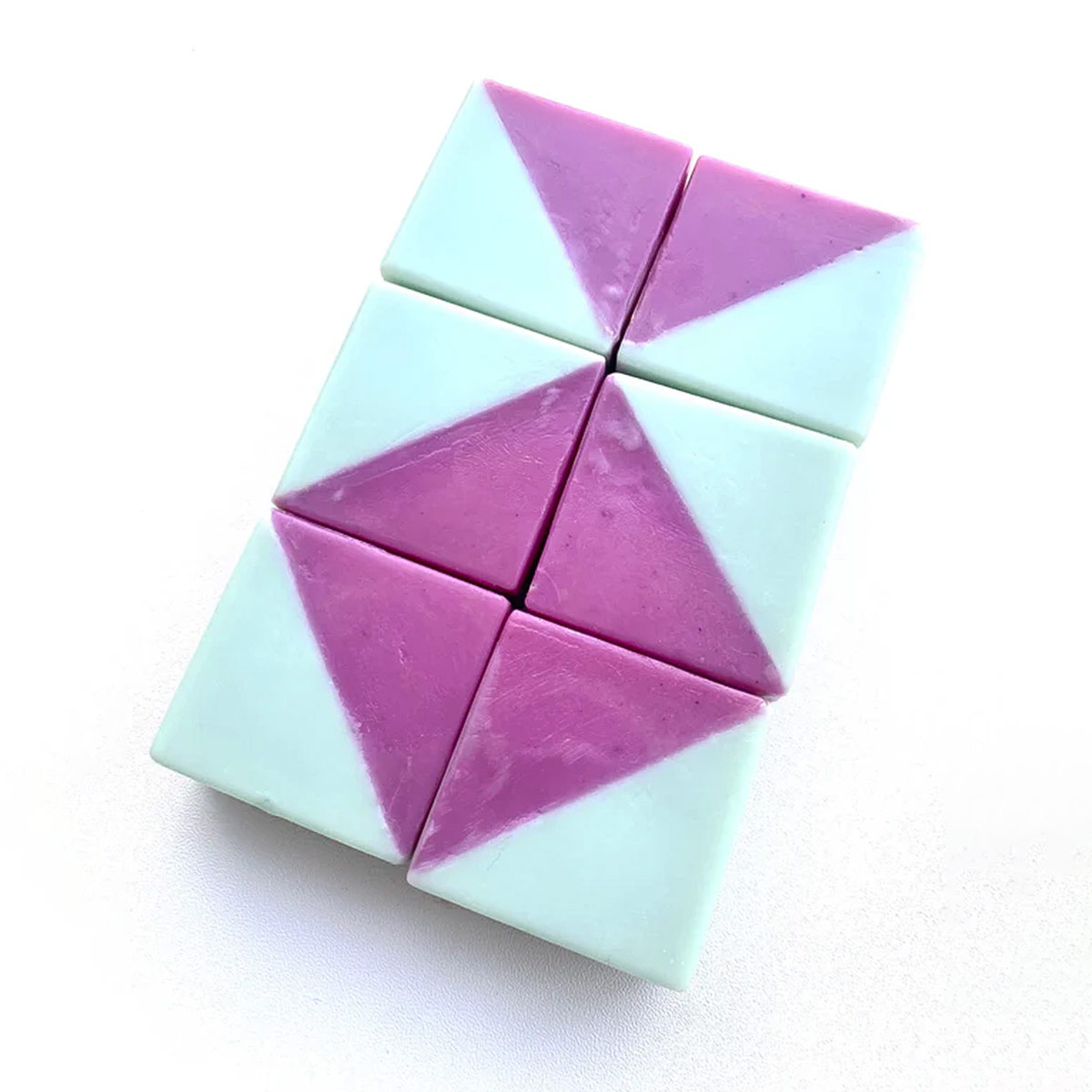 Bunte Pflegeseife „RONJA – Limone & Rosmarin“ in geometrischer Form mit klaren Kanten, zweifarbig in kräftigem Türkis und Lila, liegend auf heller Oberfläche; handgemachte, vegane 40-g-Seife für normale Haut.