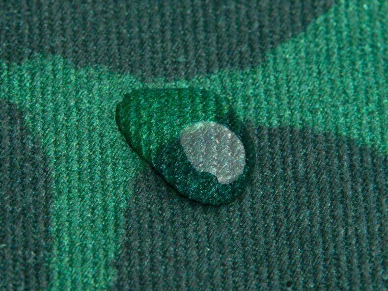 Nahaufnahme eines Tropfens auf dem wasserabweisenden Stoff des Turtle Kinderrucksacks von DonFisher.