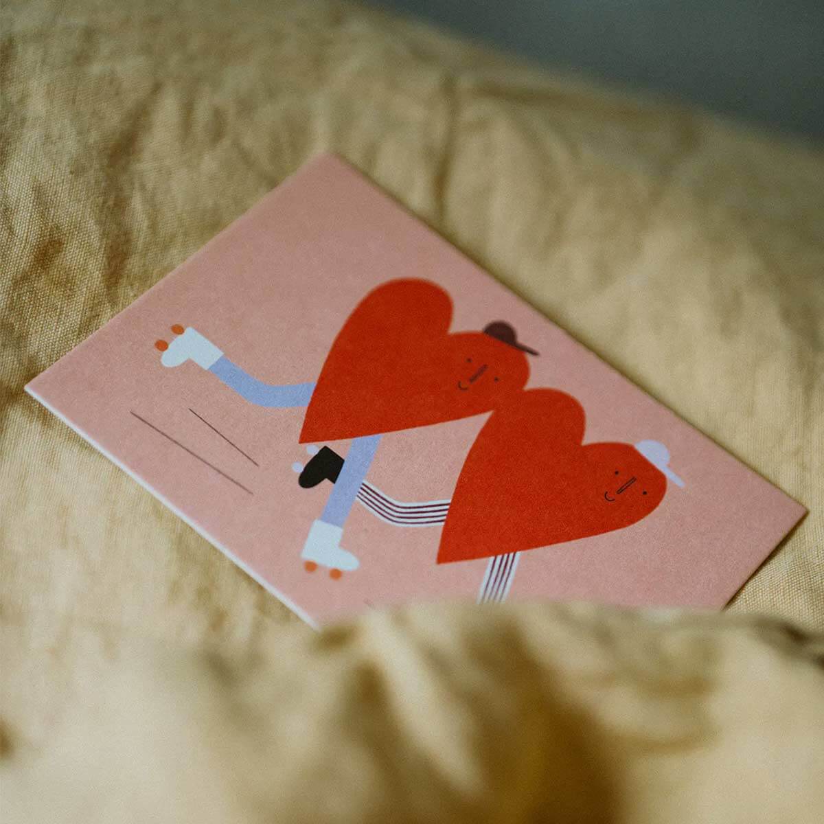 Illustrierte Postkarte mit zwei Herzen auf Rollschuhen als Valentinstagskarte, Liebeskarte und Grußkarte für besondere Herzensmenschen.