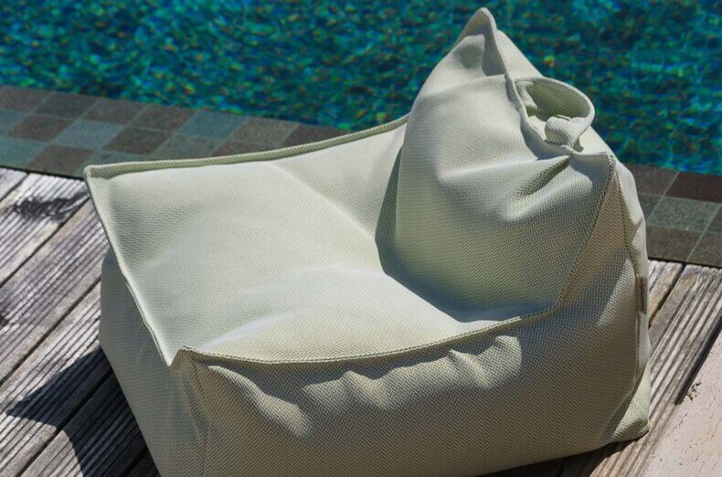 Grüner Outdoor-Sitzsack Herba von Wigiwama steht neben einem Pool – gemütlicher, wetterfester Beanbag, ideal für Garten und Terrasse.